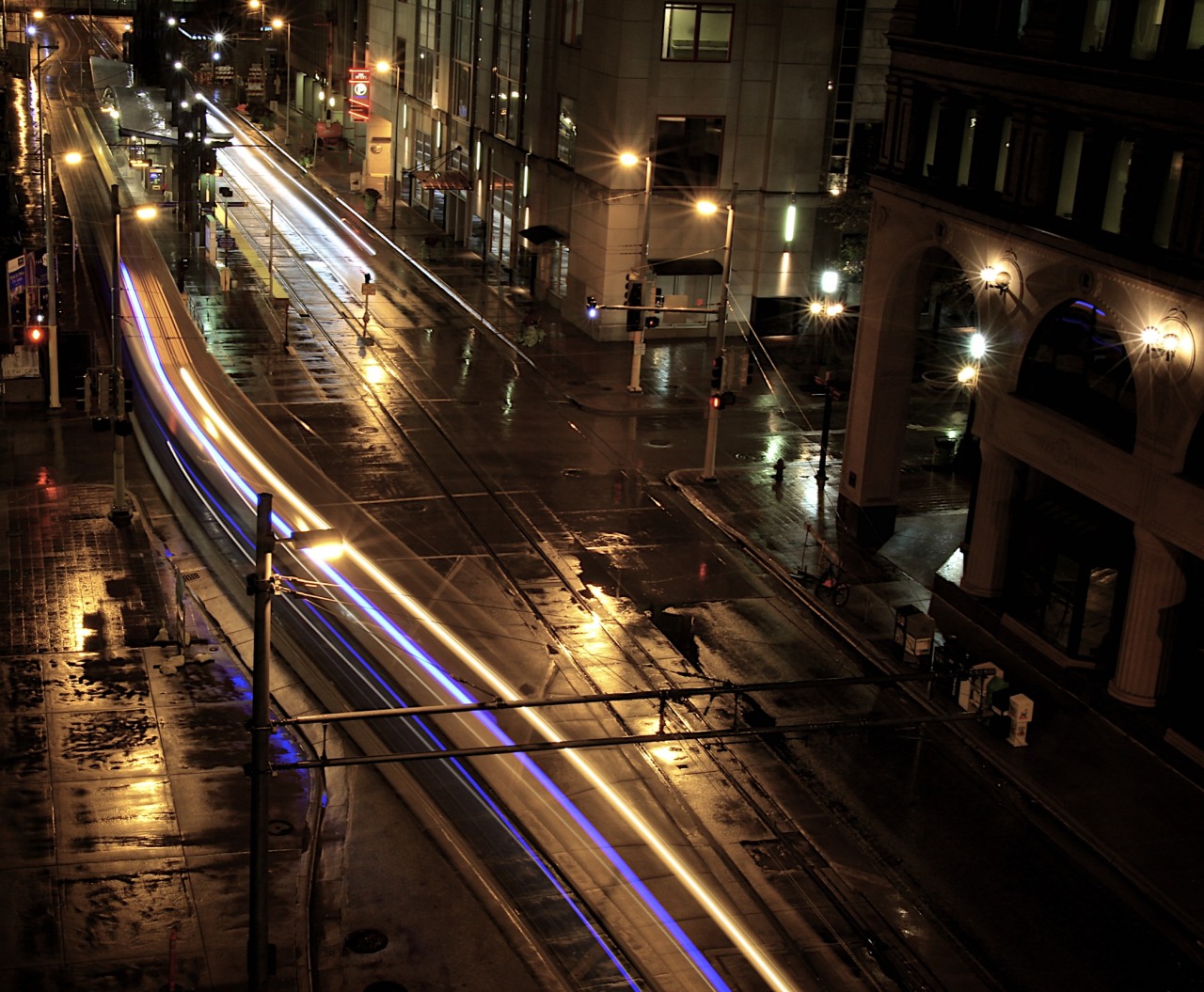 Light rail lights streaking through downtown Minneapolis on a rainy October night.