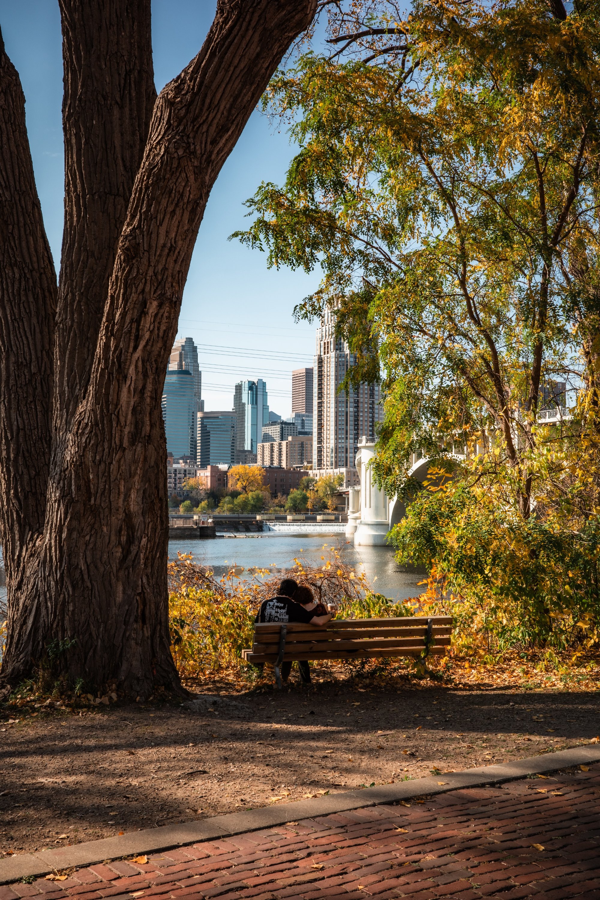 Person sitting on a bench on the river - St. Anthony Main - Minneapolis